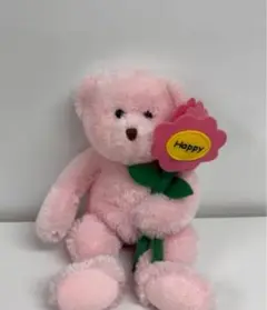ピンクの花を持ったクマのぬいぐるみ