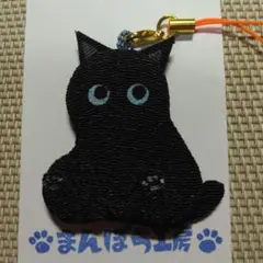 スコ座りの猫のストラップ、黒猫、青い目