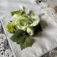 緑色のバラと黄色の花のコサージュ
