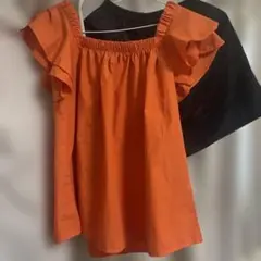 オレンジフリル袖シャツと黒ショートパンツセット