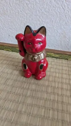 片手を上げた赤い招き猫