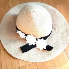 ベージュの花飾り付き麦わら帽子