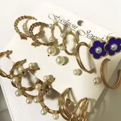 ゴールドの複数のピアスと青色のお花のピアス