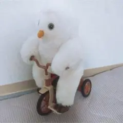 自転車に乗った白いぬいぐるみ