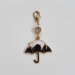 黒い傘の上の白猫チャーム