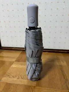 グレーの折りたたみ傘、晴雨兼用で便利。