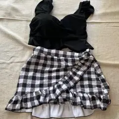 フリル付きブラックトップとチェックラップスカート