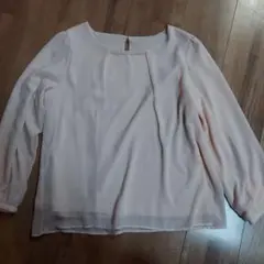 淡いピンクの長袖ブラウス