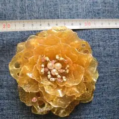オレンジ色の花型コサージュ