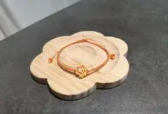 オレンジ色のブレスレットに、ツートンカラーの蓮の花チャームが付いています。