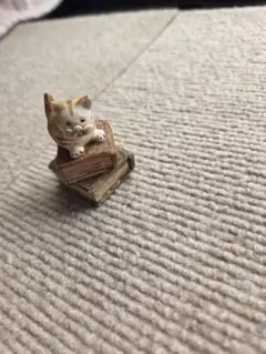 猫のミニチュアフィギュア 本の上に座る