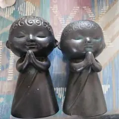 黒色の手を合わせた置物二体