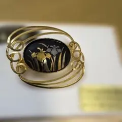 エレガントな金色と黒色のブローチ