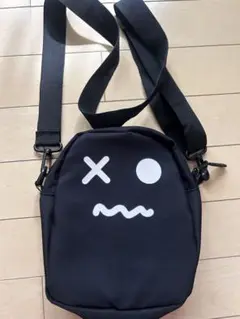 顔プリントの黒いショルダーバッグ