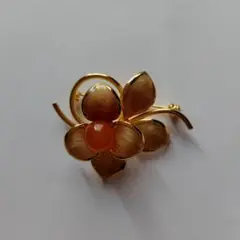 花の形状の金色ブローチ