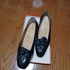 ヒロフの黒いレザーフラットシューズ 花の装飾