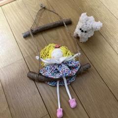 ブランコに乗った人形と白い犬のぬいぐるみ
