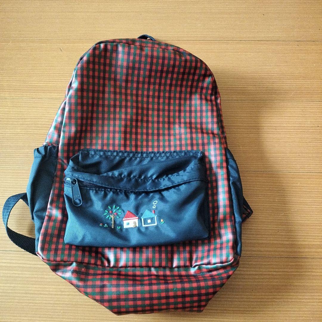 赤と黒のチェック柄小型リュックと衣類