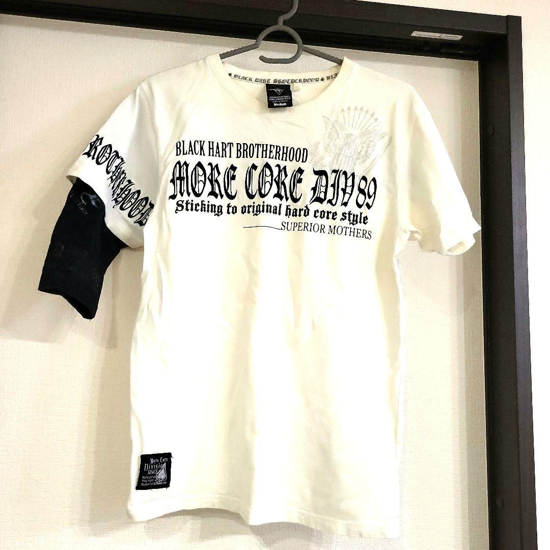 MCD白いTシャツに英語の文字入り右のそでにオシャレな短い黒いそで付き。