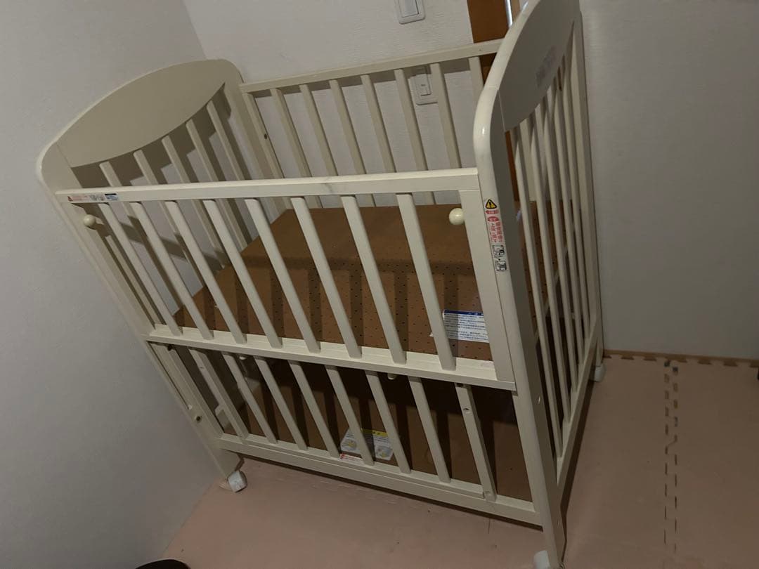 アイボリーの木製ベビーベッド