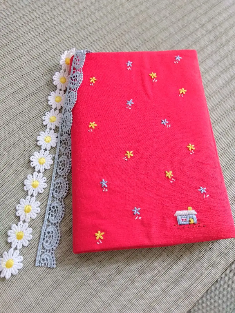 Thumbnail of Embroidered cover: A single house in a flower field