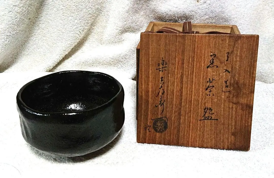 Thumbnail of Raku ware tea bowl, black glaze, by Nyūnyū, with wooden box A436