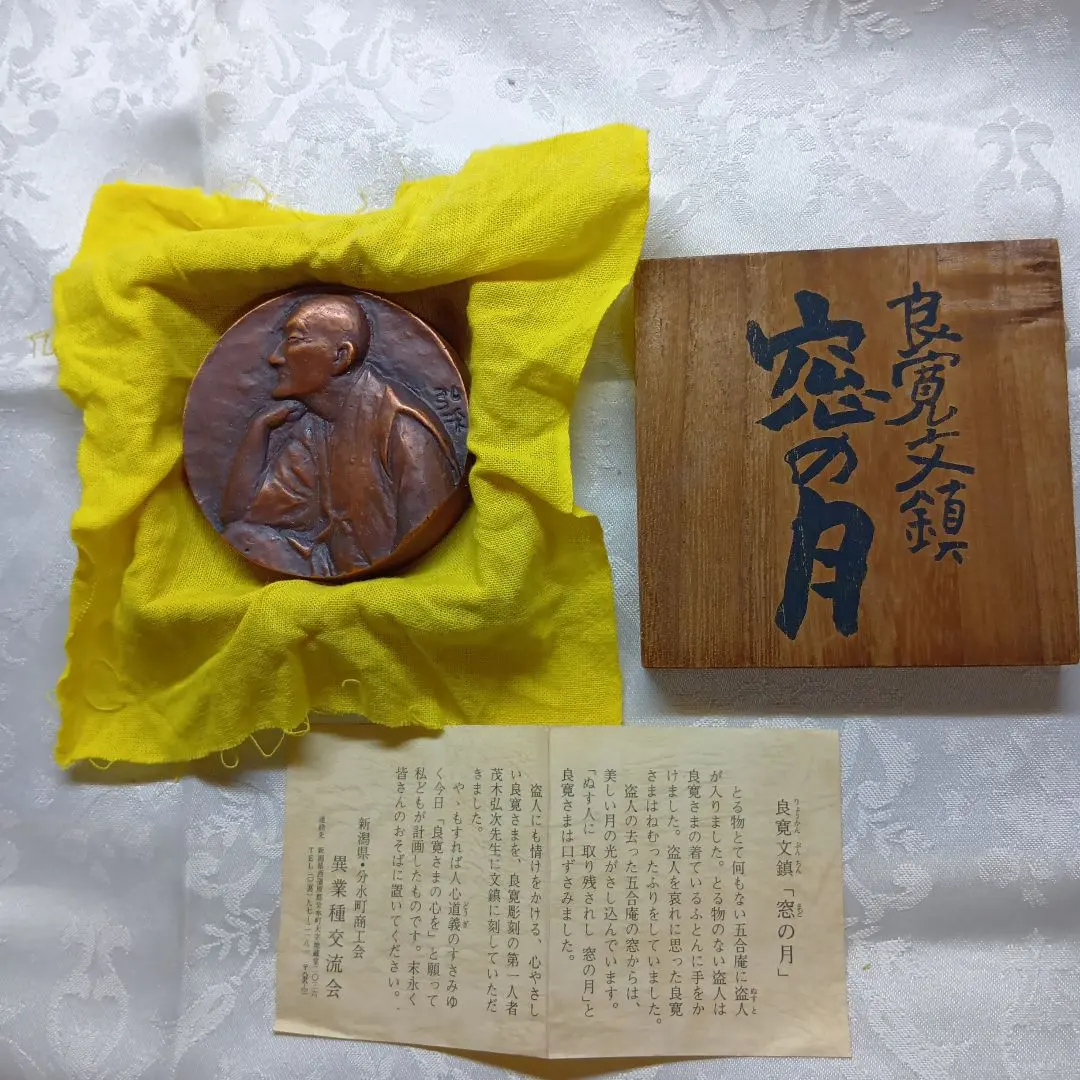 Thumbnail of Copper made Ryokan paperweight, with artist's name, "Moon in the Window," with wooden box and yellow cloth bookmark.
