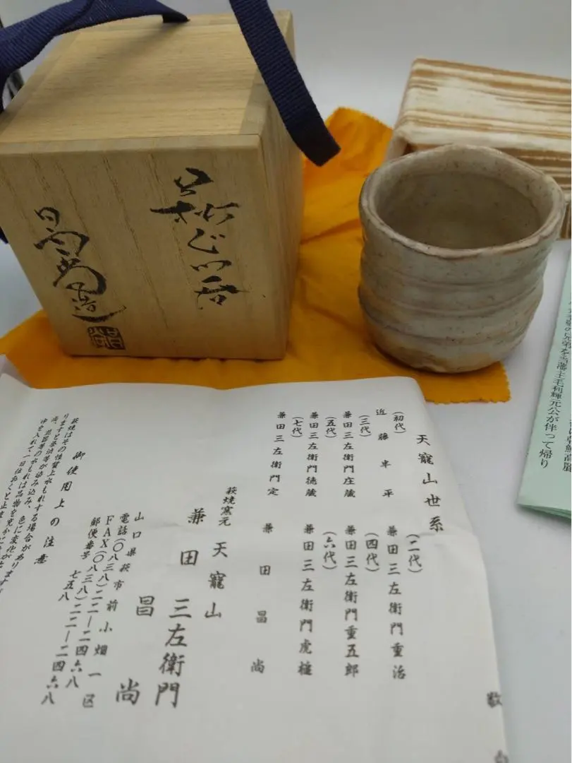 Thumbnail of Unused Hagi-yaki sake cup (guinomi), in a square paulownia wood box, with a tag and storage cloth.