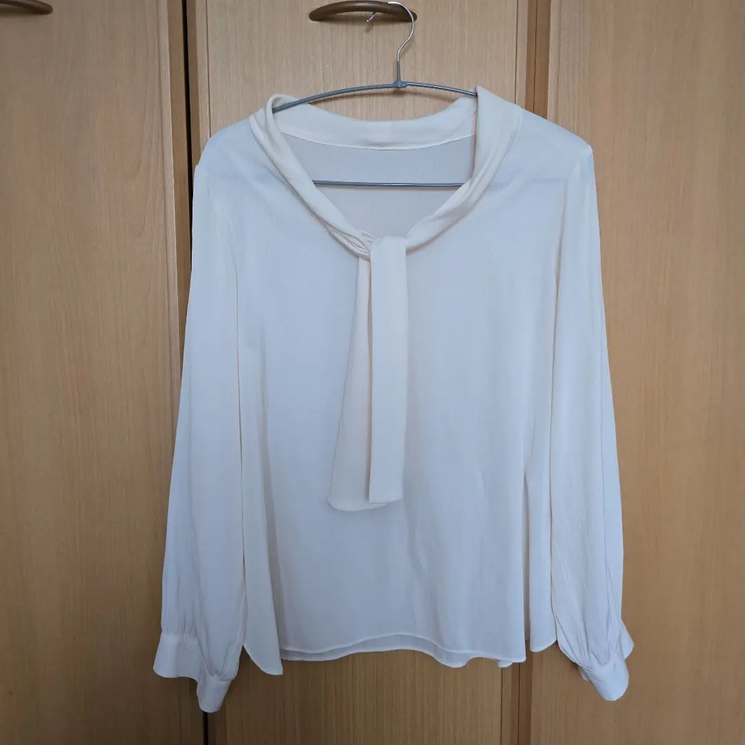 Thumbnail of Beautiful, only tried on, white long-sleeved blouse with ribbon