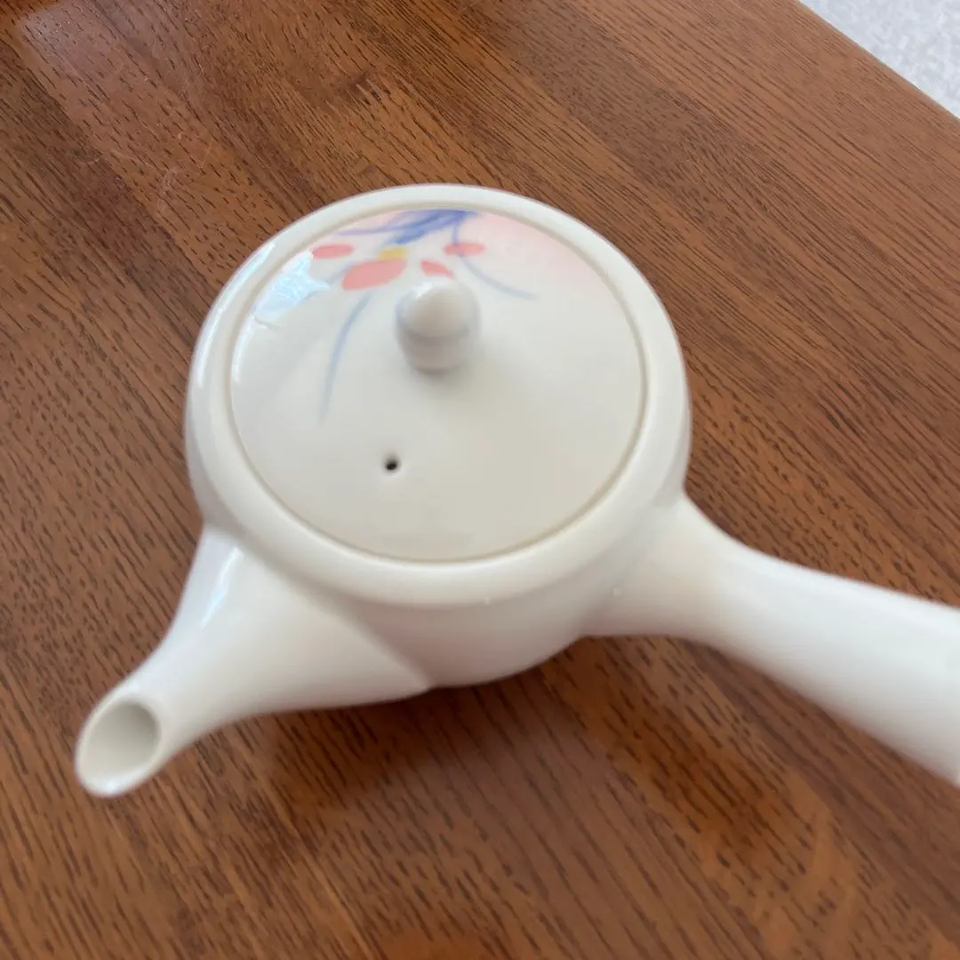 Thumbnail of Ceramic teapot with floral pattern and tea strainer