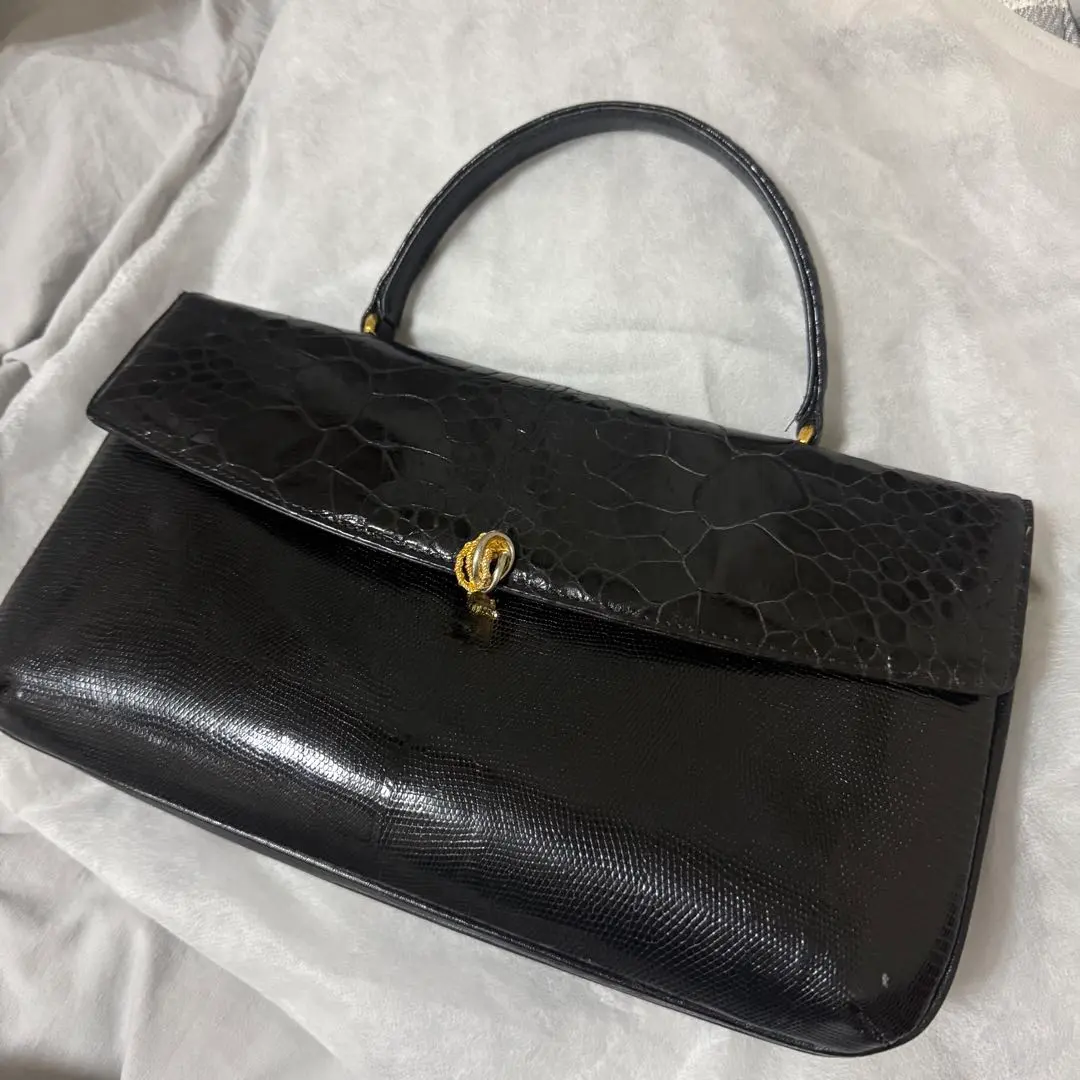 Thumbnail of Black leather clutch bag, crocodile pattern