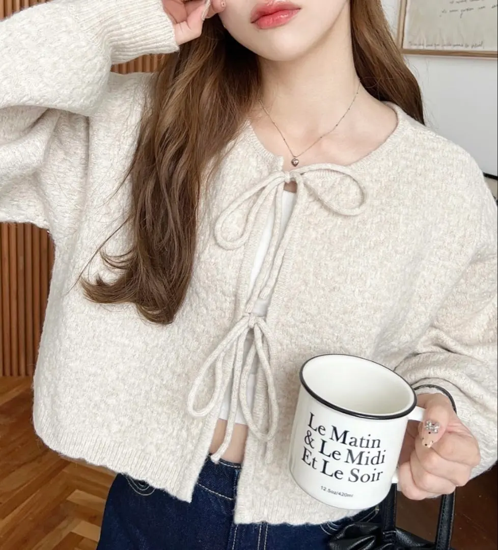 Thumbnail of Cream-colored knit sweater with ribbon