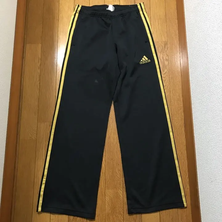 Thumbnail of Adidas track pants, size M, black with gold stripes