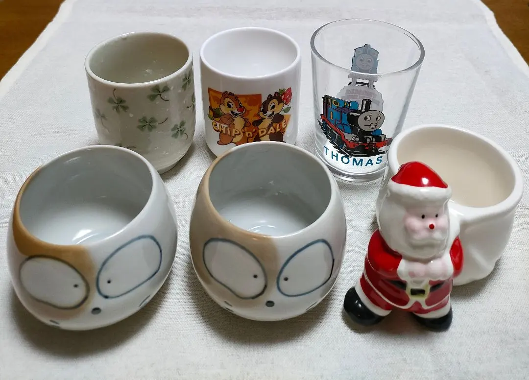 Thumbnail of Total 6 items: 2 new teacups, Santa Claus ceramic figurine, 2 children's teacups, character glass.
