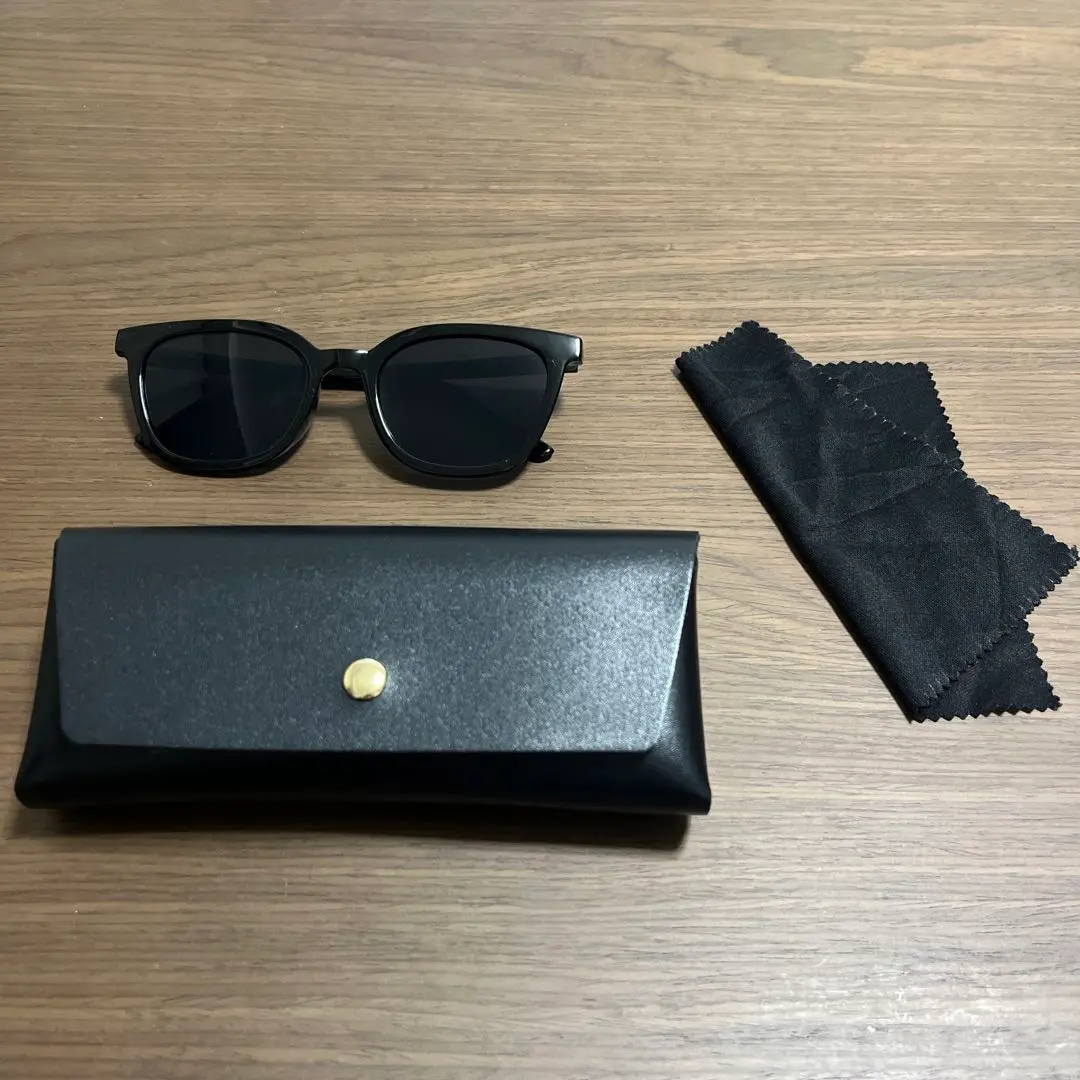 Thumbnail of Black oval sunglasses with case and cloth