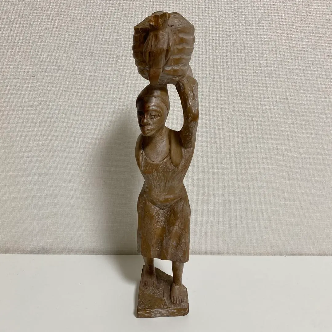 木製女性雕像，頭頂行李設計 的縮圖