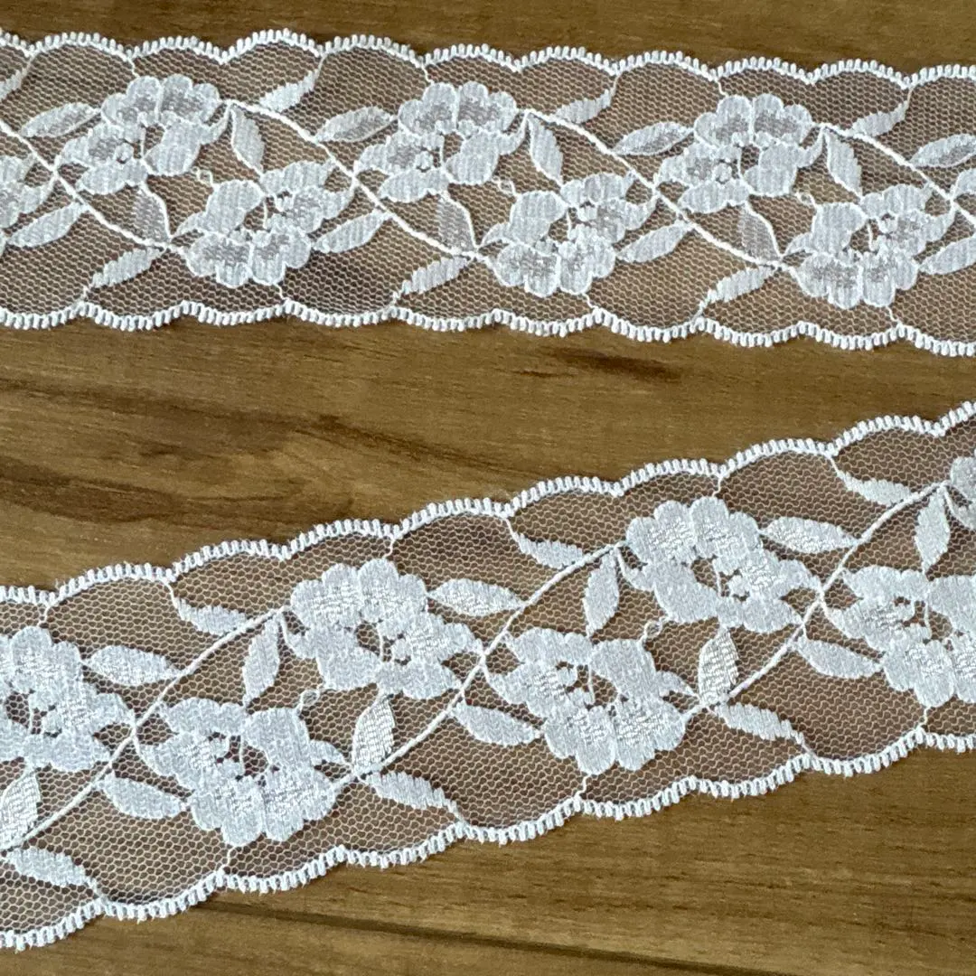 Thumbnail of White floral lace fabric, approximately 5cm wide, approximately 585cm long