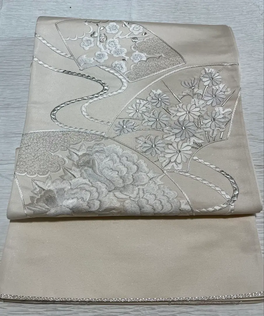 Thumbnail of Unused floral folding fan, off-white, elegant, with stains