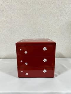 Three-tiered bento box with cherry blossom pattern, perfect for New Year's celebrations, cherry blossom viewing, or as a lunchbox. Japanese tableware, lacquerware style, red, cherry blossom design.