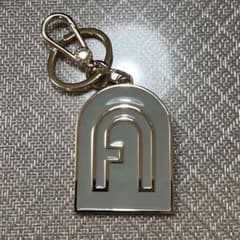 FURLA キーホルダー アーチロゴ ゴールド グレーのサムネイル