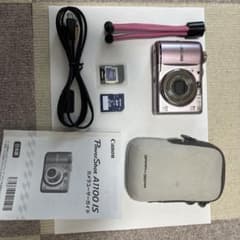 Canon PowerShot A1100 IS body (pink) with mini tripod and other accessories.