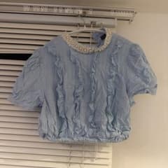 半袖の青いフリルトップスのサムネイル