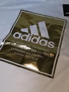 アディダス　Tシャツ　白地 ゴールドロゴ　ナイキーブランドロゴのサムネイル