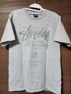 Stüssy ワールドツアー Tシャツ グレー Lサイズのサムネイル