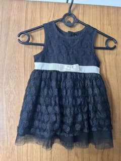 黒いドレスに白いリボンがあしらわれた服が、赤ちゃんによく似合っています。のサムネイル