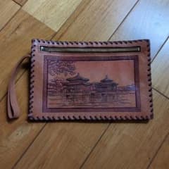 Leather clutch bag with peacock and architectural pattern