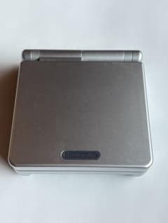 Game Boy Advance SP Silver, includes box, manual, and charger. Mario game. Tested and working. Excellent condition.