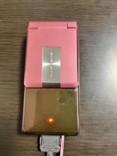 SH903iTV ピンク 折りたたみ式携帯電話 本体と純正充電器のサムネイル