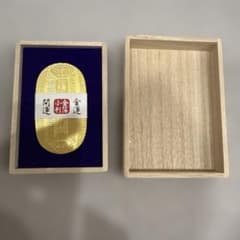Gold leaf coin, good luck charm, for attracting wealth, in a wooden box.