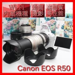 Stylish white Canon EOS R50 with triple lens and spare battery.